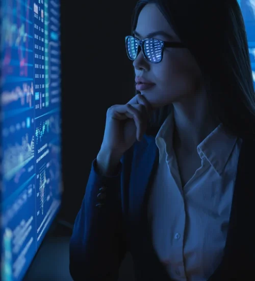business-woman-looks-large-blue-screen-with-chart-scaled-1